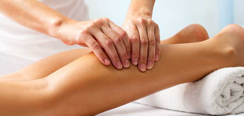 Sportsperson getting a massage done to calf muscle at a massage centre.