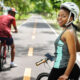 Smiling Woman Starring Towards The Camera With Her Bicycle.