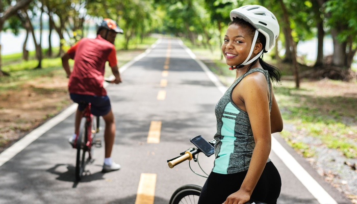 Smiling Woman Starring Towards The Camera With Her Bicycle.